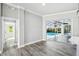 Dining area with sliders to screened-in lanai and pool with gray wood floors at 8818 Poe Dr, Hudson, FL 34667