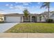 Inviting single-story home with a lush green lawn, attached garage, and covered front entryway at 8818 Poe Dr, Hudson, FL 34667