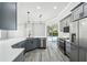 Bright kitchen featuring gray cabinets, stainless appliances, and quartz countertops at 8818 Poe Dr, Hudson, FL 34667