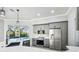 Kitchen view with stainless steel appliances, gray cabinets, and pool view at 8818 Poe Dr, Hudson, FL 34667