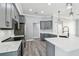 Stylish kitchen showcasing gray cabinetry, stainless appliances, and quartz countertops at 8818 Poe Dr, Hudson, FL 34667