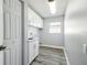 Convenient laundry room with gray plank flooring, storage cabinets, and a utility sink at 8818 Poe Dr, Hudson, FL 34667