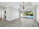 Large living room with wood flooring, trey ceiling, and access to the screened lanai and pool area at 8818 Poe Dr, Hudson, FL 34667