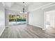 Bright living room with wood flooring, trey ceiling, and large sliding glass doors to the pool at 8818 Poe Dr, Hudson, FL 34667