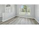 Open living room space featuring wood-look floors and a bright window providing natural light at 8818 Poe Dr, Hudson, FL 34667