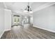 Open-concept living area with wood floors, trey ceiling, and decorative front doors and windows at 8818 Poe Dr, Hudson, FL 34667