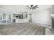 Hardwood floors accent the living room, with a kitchen view and a fireplace at 8818 Poe Dr, Hudson, FL 34667