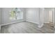 Bright living room featuring wood-look floors and a large window providing natural light at 8818 Poe Dr, Hudson, FL 34667