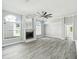 Bright living room featuring a fireplace, hardwood floors, large windows, and a ceiling fan at 8818 Poe Dr, Hudson, FL 34667