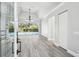 Bright, open-concept living room with wood flooring, trey ceiling, and sliding glass doors to the pool area at 8818 Poe Dr, Hudson, FL 34667