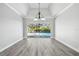 Spacious living room with wood flooring and expansive sliding glass doors overlooking the lanai and pool at 8818 Poe Dr, Hudson, FL 34667