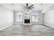 Spacious living room showcasing hardwood floors, large windows, ceiling fan, and a fireplace at 8818 Poe Dr, Hudson, FL 34667