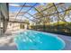 Outdoor screened pool area with large deck and mature landscaping at 8818 Poe Dr, Hudson, FL 34667