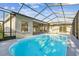 Outdoor screened pool area with large deck and mature landscaping at 8818 Poe Dr, Hudson, FL 34667