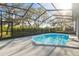 Outdoor screened pool area with a beautiful view and mature landscaping at 8818 Poe Dr, Hudson, FL 34667