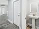 Downstairs powder room with pedestal sink and gray plank flooring at 8818 Poe Dr, Hudson, FL 34667
