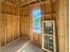 Framed interior with a window opening showing lush outdoor foliage and a new window leaning against the wall at 921 12Th N St, St Petersburg, FL 33705