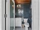 Stylish bathroom with gray brick tile, round mirror and white vanity and toilet at 1112 38Th Ne Ave, St Petersburg, FL 33704