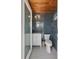 Stylish bathroom with gray brick tile, round mirror and white vanity and toilet at 1112 38Th Ne Ave, St Petersburg, FL 33704