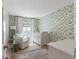 Cozy Bedroom featuring patterned wallpaper, a crib, and a comfortable armchair at 1112 38Th Ne Ave, St Petersburg, FL 33704