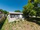 Large backyard with a patio, green grass, and mature trees at 12202 Meadowbrook Ln, Hudson, FL 34667