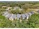 Aerial view of multiple two-story homes with trees surrounding the neighborhood and other homes nearby highlighting landscape at 1353 Curlew Rd, Dunedin, FL 34698