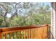 This cozy balcony features wood floors and railings, providing a perfect spot to enjoy the surrounding greenery at 1353 Curlew Rd, Dunedin, FL 34698