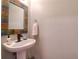 Charming half bathroom with decorative framed mirror, pedestal sink and sleek faucet at 1353 Curlew Rd, Dunedin, FL 34698