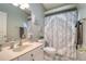 Bright bathroom features a vanity with decor and a shower with decorative shower curtain at 1353 Curlew Rd, Dunedin, FL 34698
