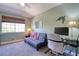 Cozy bedroom features a gray futon, large window, desk, and calming green walls at 1353 Curlew Rd, Dunedin, FL 34698