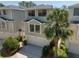 Two-story home with large windows, a two-car garage, a well-manicured lawn, and a driveway, creating a welcoming curb appeal at 1353 Curlew Rd, Dunedin, FL 34698