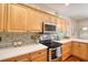 Modern kitchen with stainless steel appliances, light wood cabinets, updated countertops and a beautiful tile backsplash at 1353 Curlew Rd, Dunedin, FL 34698