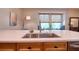 This kitchen is bright and features stainless appliances, wood cabinets, and a large window for natural light at 1353 Curlew Rd, Dunedin, FL 34698