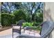 Intimate outdoor patio with wicker furniture, an outdoor rug, and lush plantings at 1353 Curlew Rd, Dunedin, FL 34698