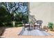 Private patio with wicker seating, decorative rug and views of mature landscaping at 1353 Curlew Rd, Dunedin, FL 34698