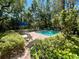 Community pool offers a refreshing escape amidst mature trees and manicured landscaping at 1353 Curlew Rd, Dunedin, FL 34698