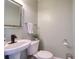 Powder room featuring a pedestal sink, toilet, and decorative mirror at 1353 Curlew Rd, Dunedin, FL 34698