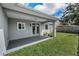 Covered patio in backyard featuring gray flooring, plants, and double doors leading inside the house at 1453 Otten St, Clearwater, FL 33755