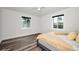 Bright bedroom boasts hardwood floors, white trim, and natural light through two windows at 1453 Otten St, Clearwater, FL 33755