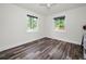 Bright bedroom featuring neutral walls, wood-look floors, ceiling fan, and a bright window view at 1453 Otten St, Clearwater, FL 33755