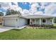 Charming single-story home with a well-manicured lawn and an attached garage at 1453 Otten St, Clearwater, FL 33755