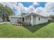 Side view of a home with a modern exterior, manicured lawn, and fresh landscaping at 1453 Otten St, Clearwater, FL 33755