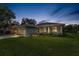 Single-story home with a well-manicured lawn, garage, and tasteful landscaping at dusk at 1453 Otten St, Clearwater, FL 33755