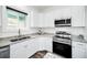 Bright kitchen features stainless steel appliances, granite countertops, and white cabinets at 1453 Otten St, Clearwater, FL 33755