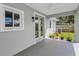 Relaxing covered patio with ceiling fan, gray flooring, double doors and view of the backyard at 1453 Otten St, Clearwater, FL 33755