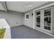 View of the gray concrete patio with ceiling fan and view of backyard through double doors at 1453 Otten St, Clearwater, FL 33755