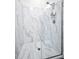 Luxurious walk-in shower with marble tiling, a glass enclosure, and modern fixtures at 1453 Otten St, Clearwater, FL 33755