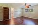 Bright bedroom features hardwood floors, a ceiling fan, and shelf space above a nearby doorway at 1572 84Th N Ave, St Petersburg, FL 33702
