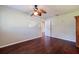 Spacious bedroom with wood floors, ceiling fan, and adjacent doorway at 1572 84Th N Ave, St Petersburg, FL 33702