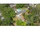 Aerial view showcases a home with a pool, surrounded by trees at 1591 Chestnut W Ct, Palm Harbor, FL 34683